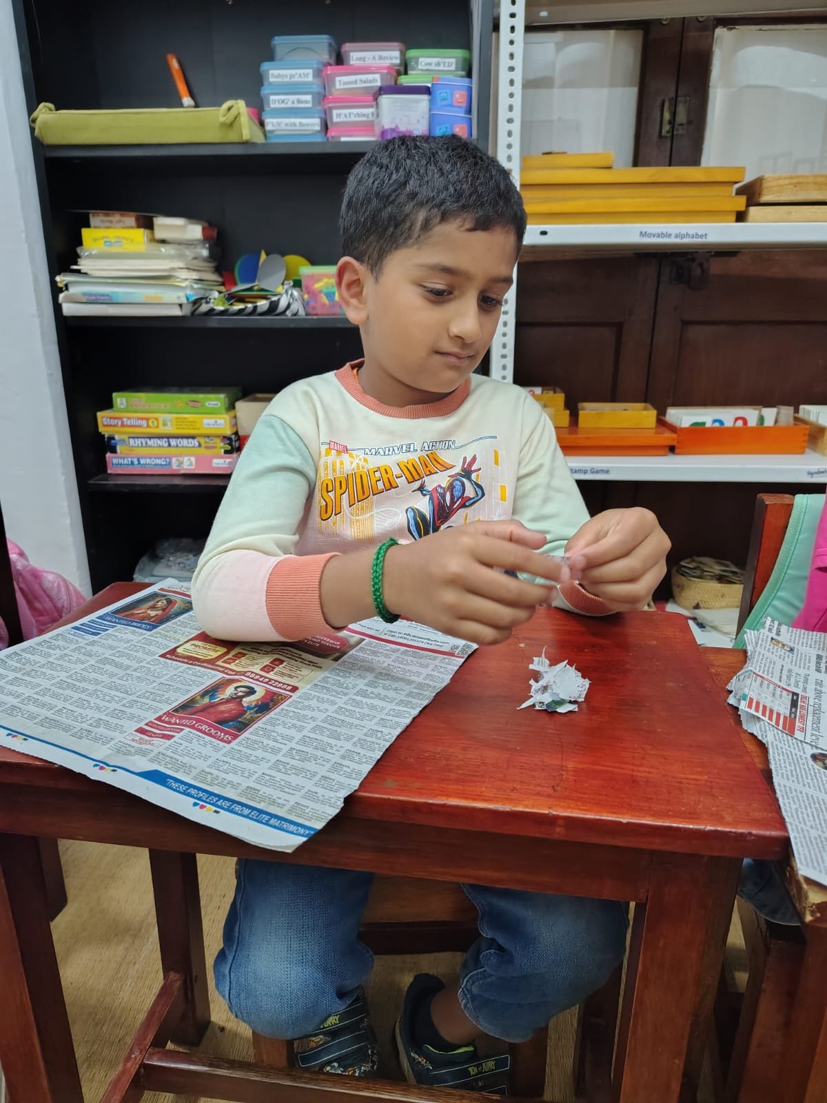 A Grade 1 child tearing old newspaper for handmade paper