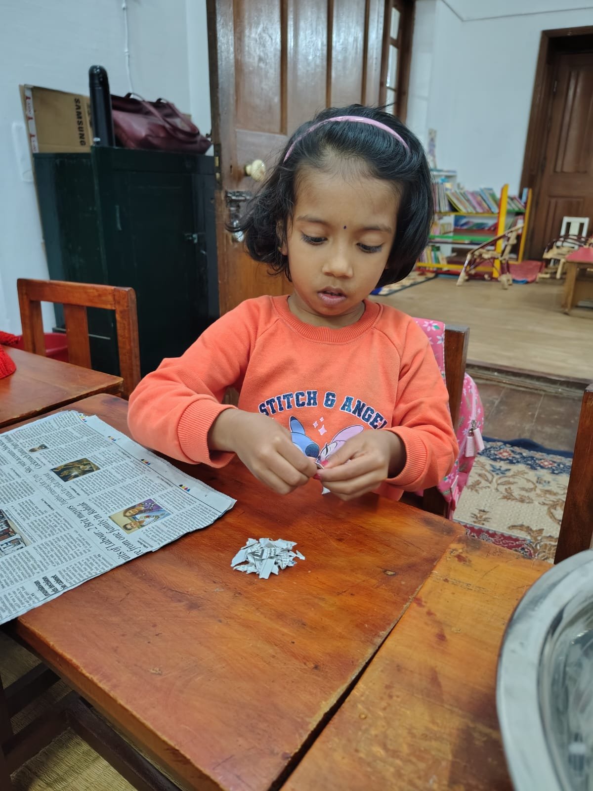 A Grade 1 child tearing old newspaper for handmade paper