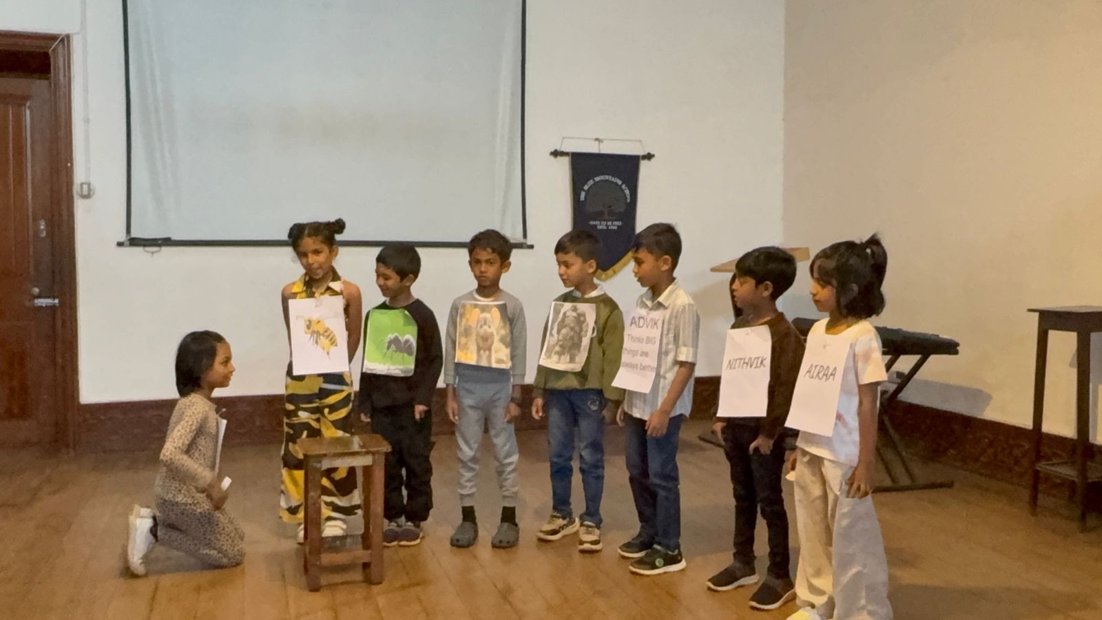 A student narrates to the assembled cast of small and large characters