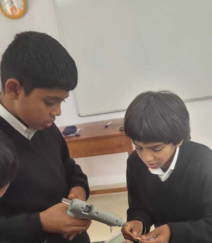 A group of students assembling a cube joint with a glue gun