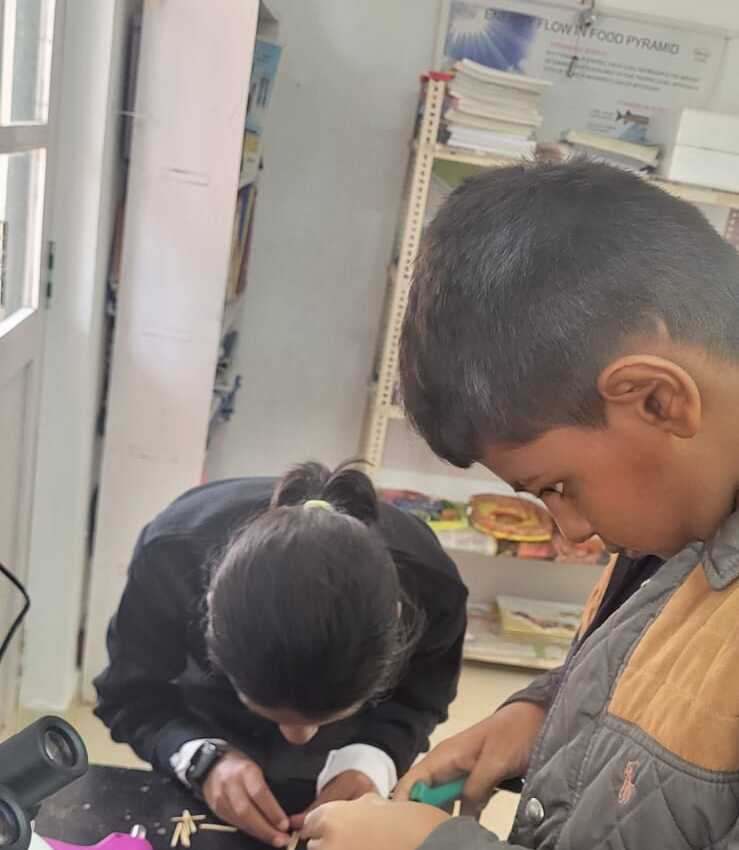 Two students working together on their matchstick cube