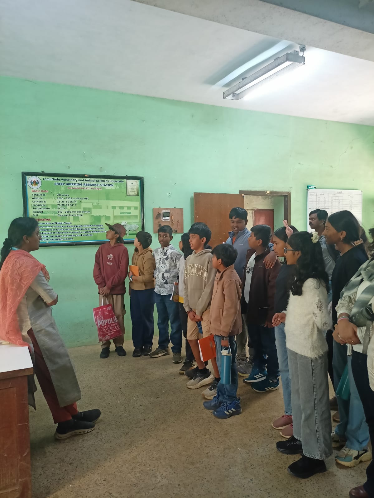 Students listening to a station staff member explain the centre's research data board