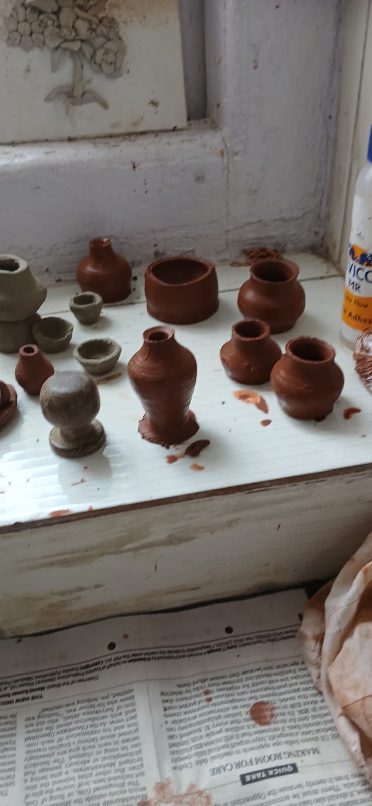 Finished clay pots and bowls drying on the windowsill