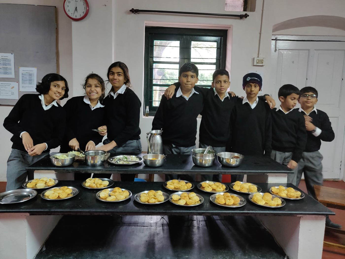 Grade 6 students with a table full of freshly fried pooris at bms